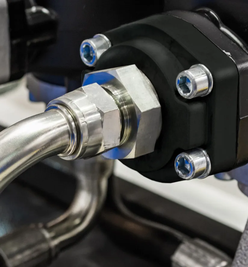 Duroplaste für die Industrie: schwarzes Pumpengehäuse mit Hydraulikverschraubungen im Maschinenbau