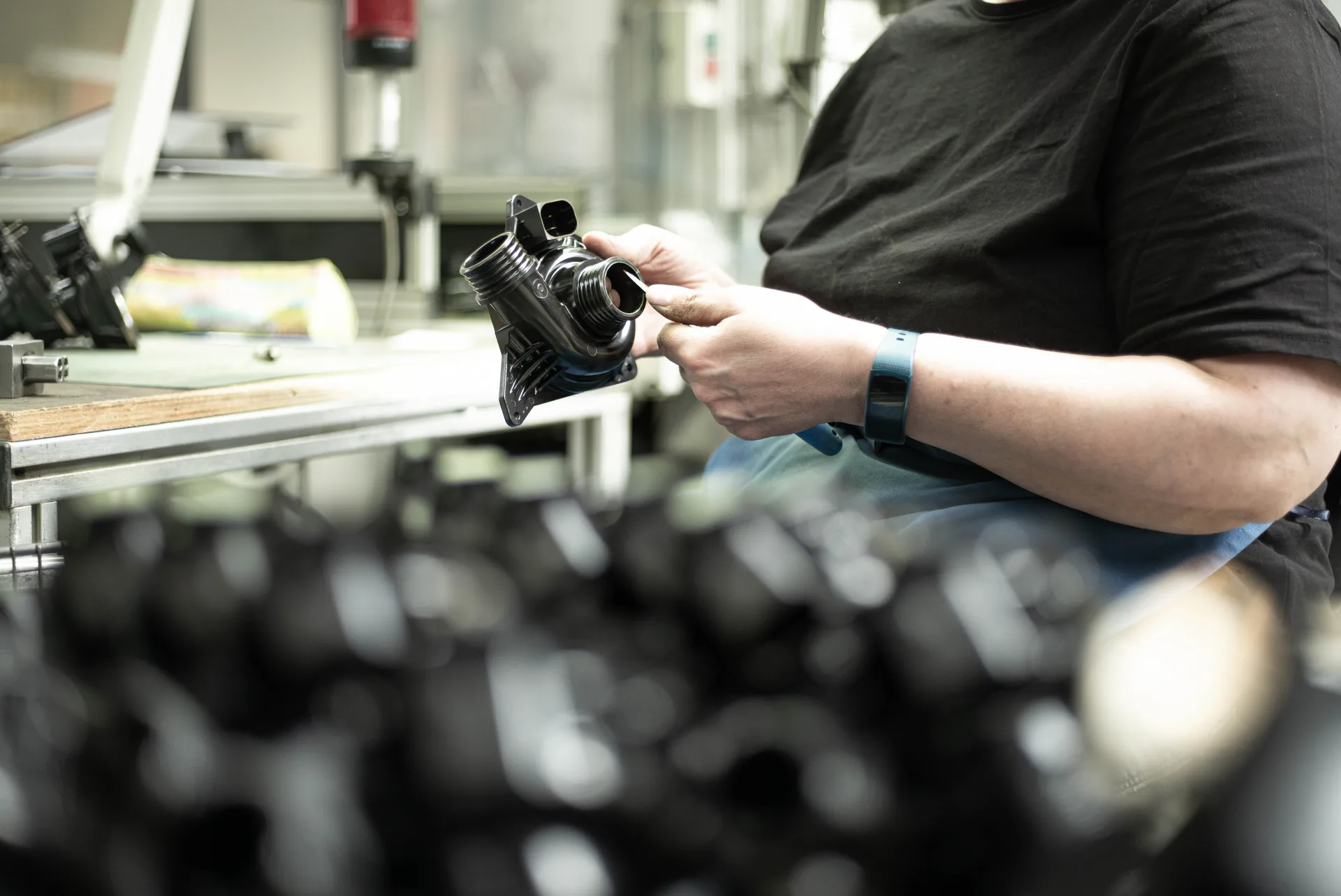 Werker hält ein schwarzes Duroplast-Pumpengehäuse als Metallersatz