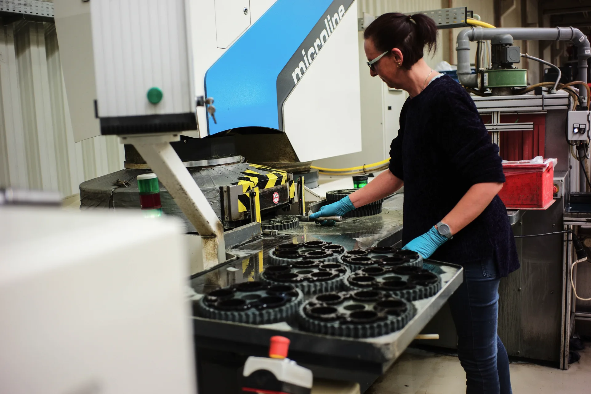 Werkerin an der Parallelschleifmaschine bei der Duroplast-Nachbearbeitung